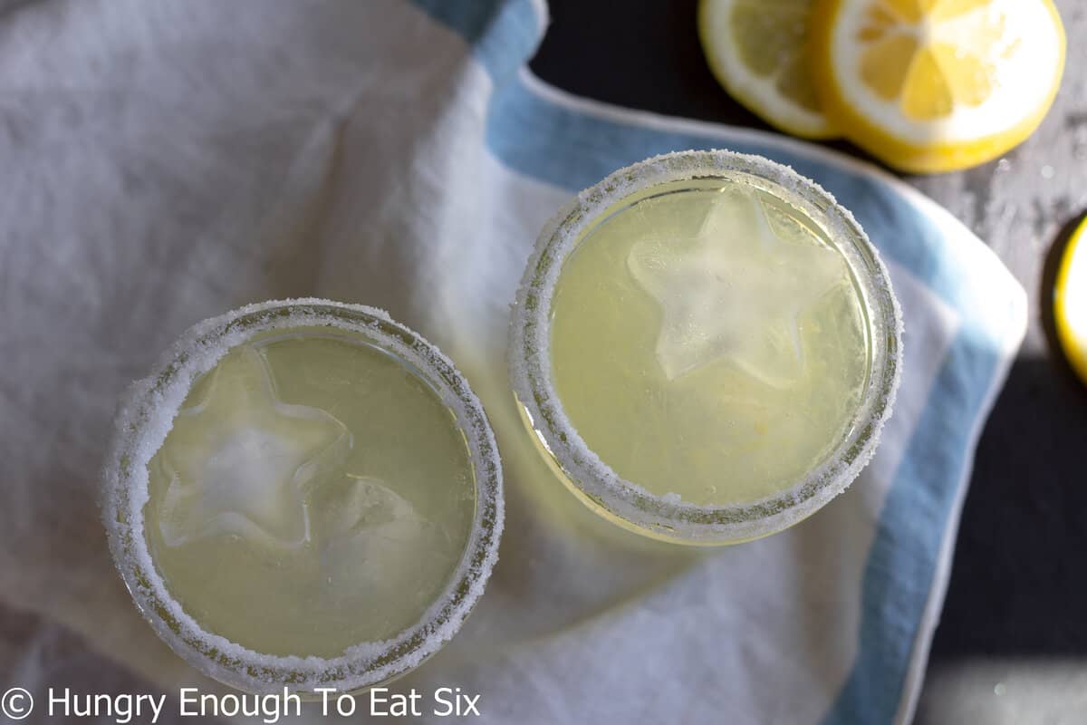 Mason jars holding lemon margaritas and ice.