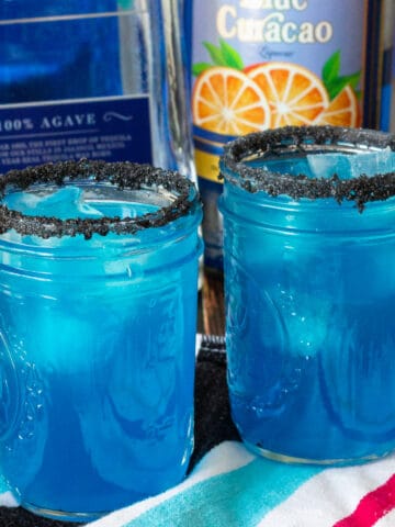 Two mason jars with blue cocktails.