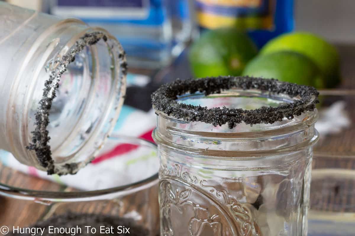 Small mason jars with black salt on rims.