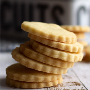 Stack of butter cookies with scalloped edges.