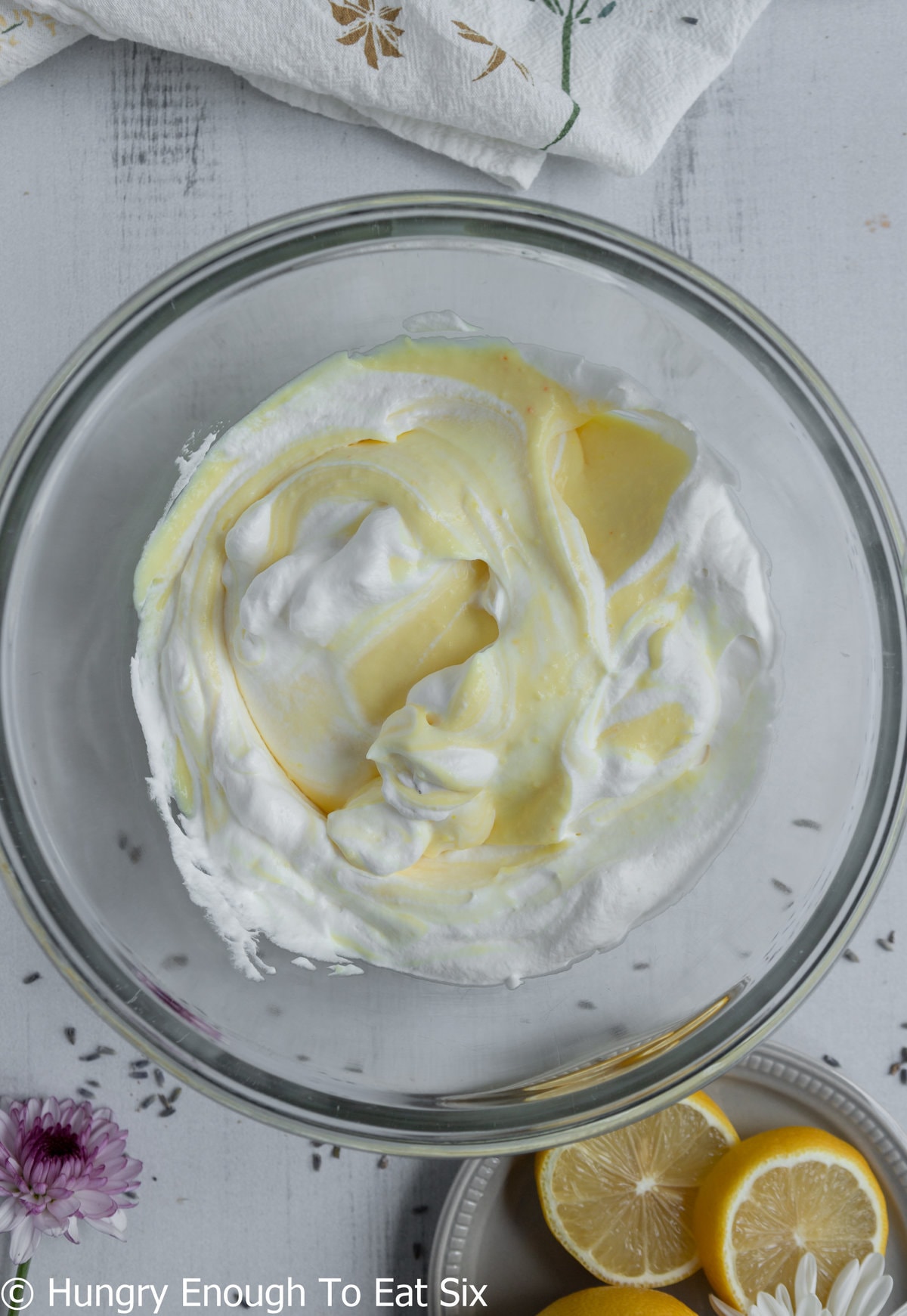 Mixture of yellow pudding and whipped cream in a bowl.