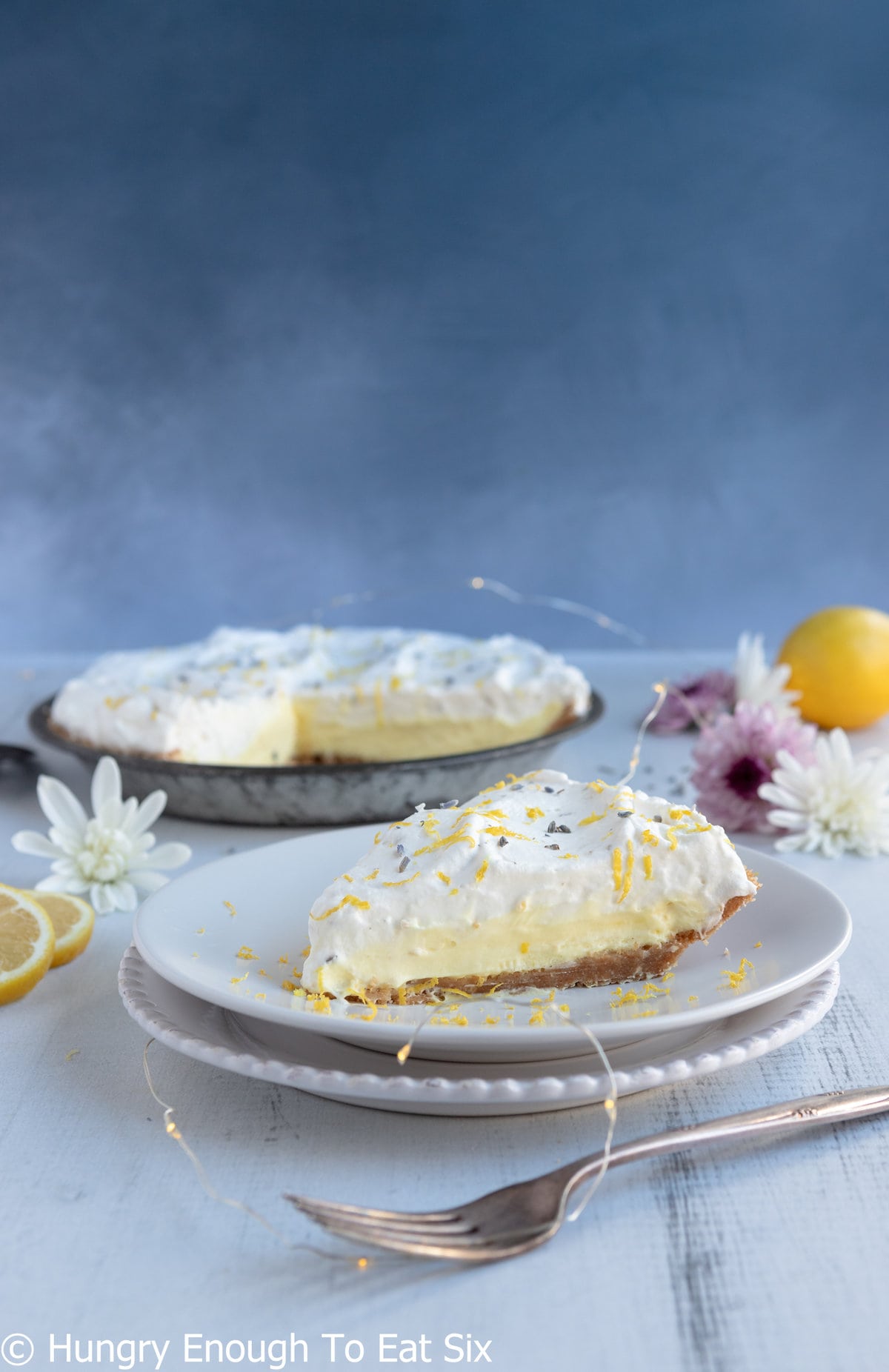 Lemon pudding pie with whipped cream top layer on plates.