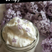 Lilac flavored whipped cream in a mason jar and lilacs behind.