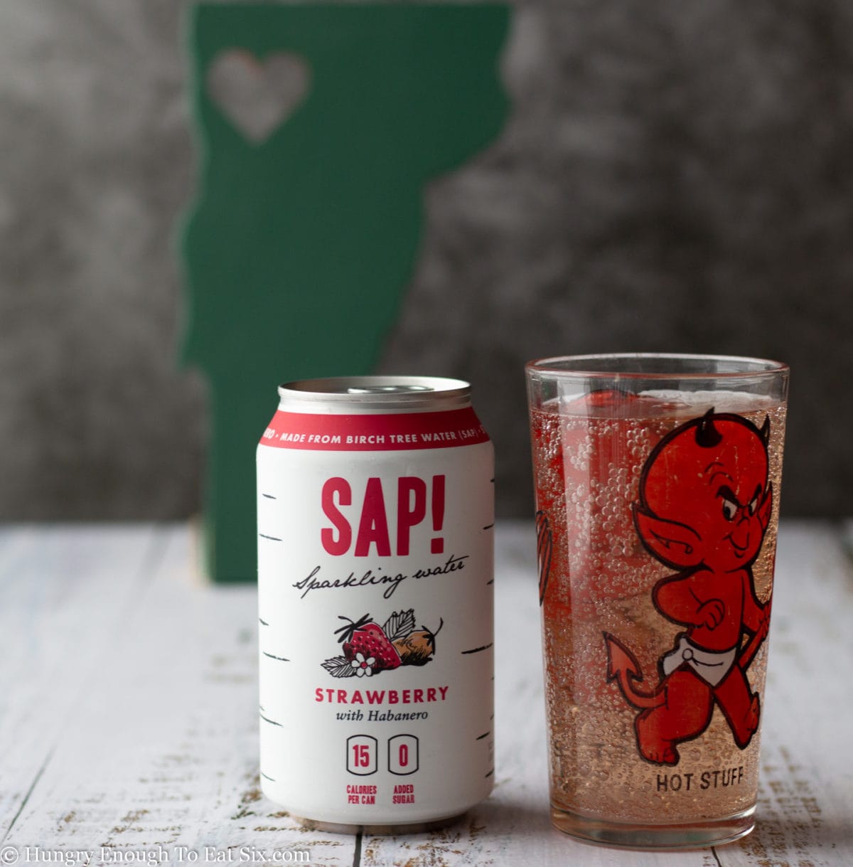 Can of Sap! beverage next to a glass of pinkish sparkling water.