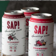 Cans of Sap! sparkling water on a white surface