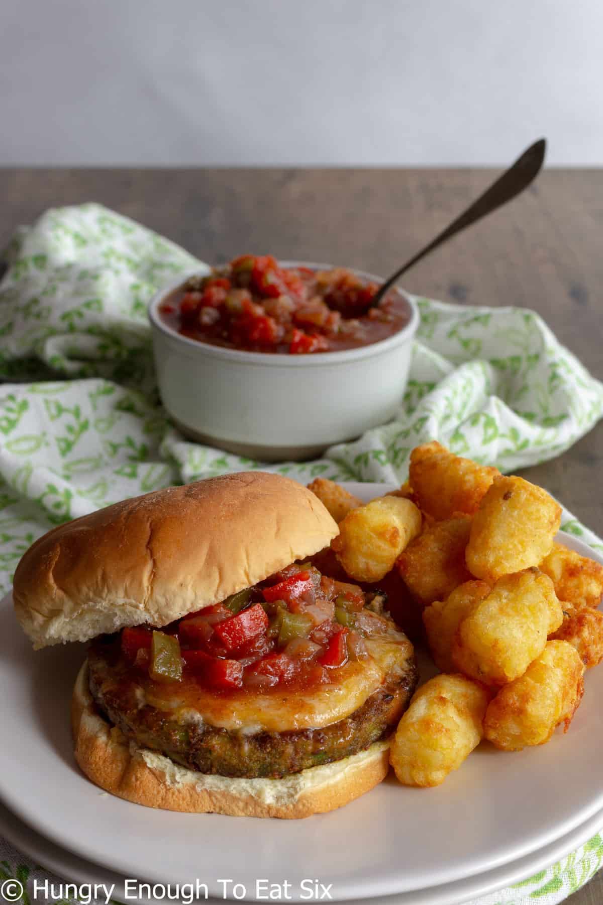 Burger spread with chilli sauce with tater tots.