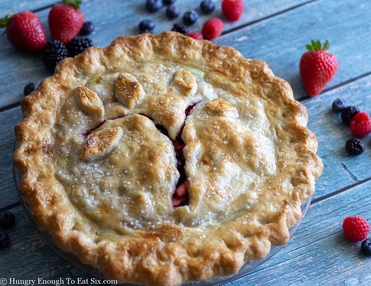 Browned, baked pie on a blue wooden surface.