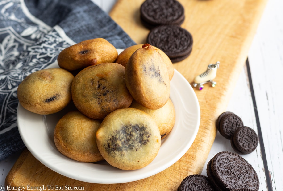 Pile of fried Oreo cookies on a round white plate