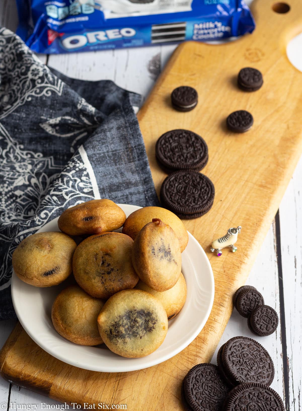Plate of fried Oreos with regular Oreos scattered behind.
