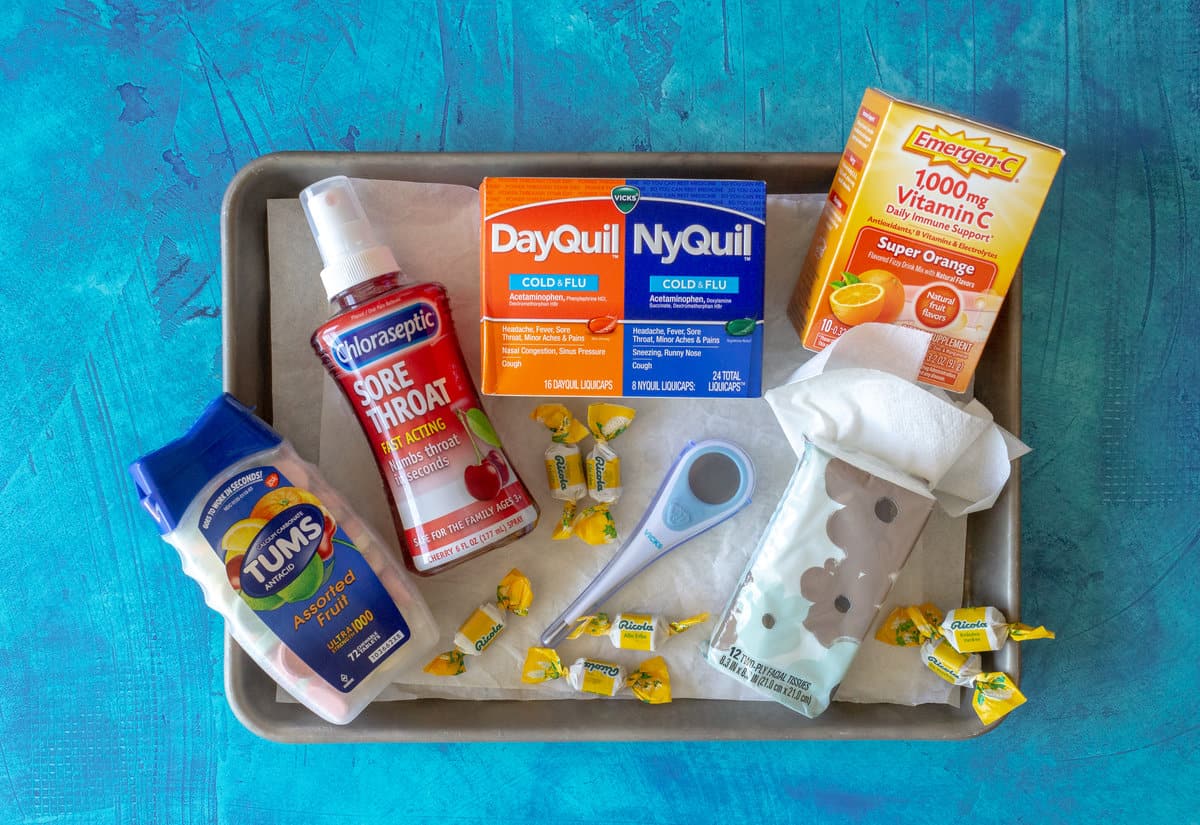 Tums, throat spray, Dayquil/Nyquild box, thermometer, tissues, and vitamin C supplements.