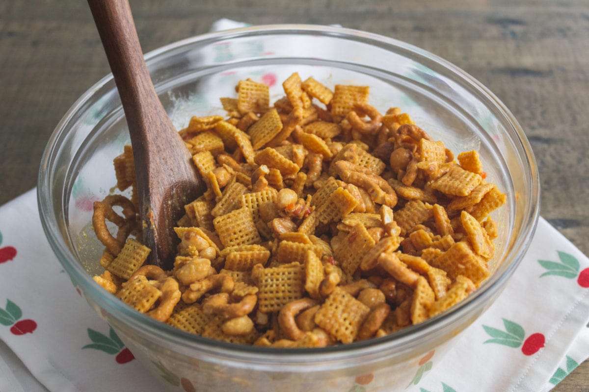 Snack mix in a glass bowl with spoon