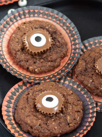 Round cupcake papers with chocolate cookies decorated with candy eyes