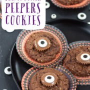 Chocolate cookies with candy eyes on a black surface