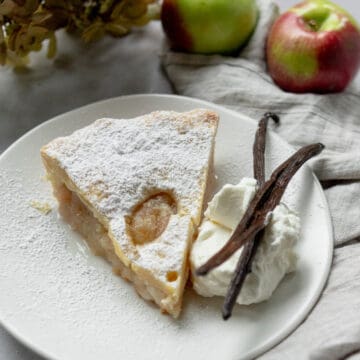Apple pie slice with whipped cream and vanilla bans.