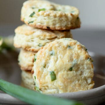 Biscuits with green onions stacked in a dish.