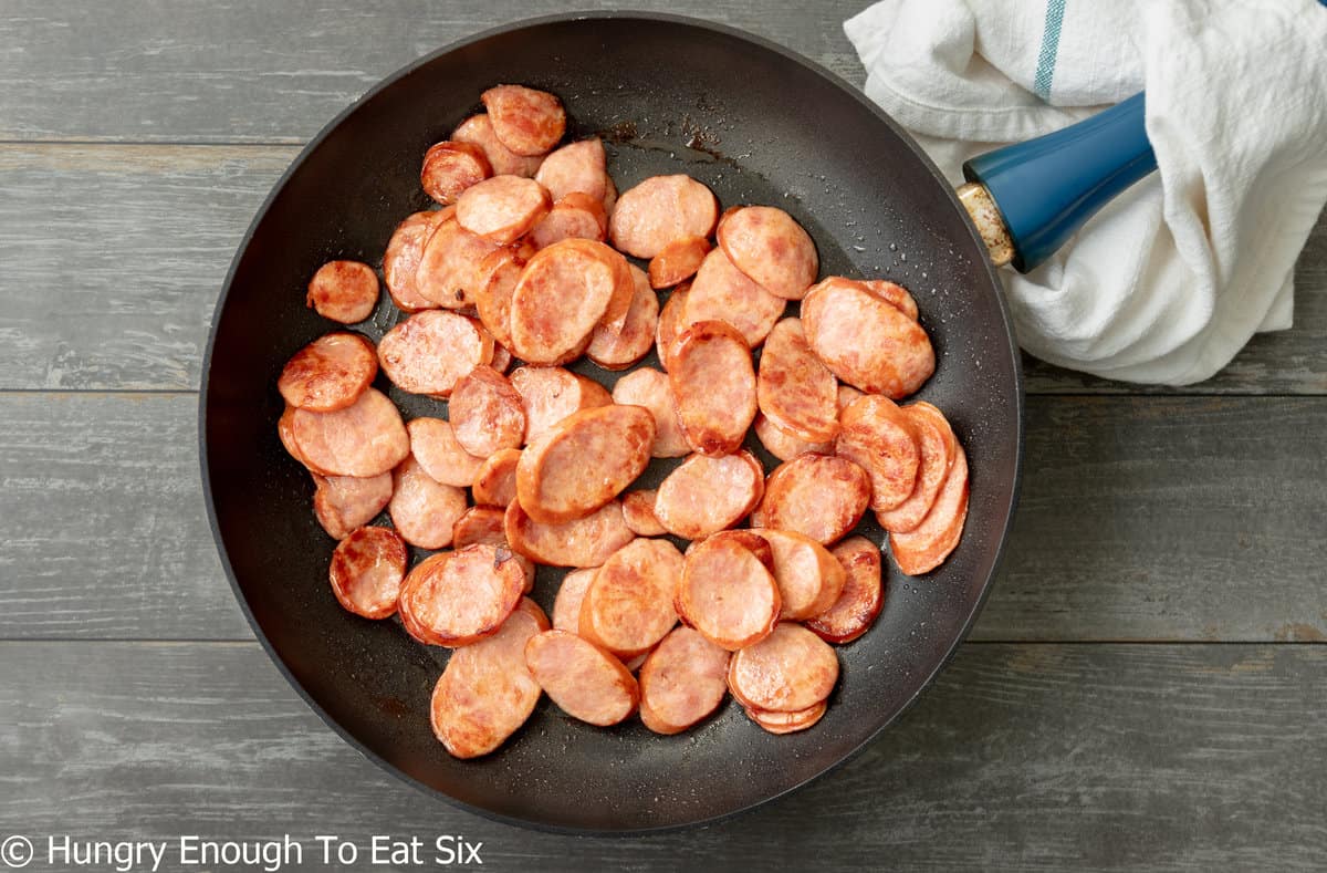Slices of kielbasa sausage browned in a skillet.