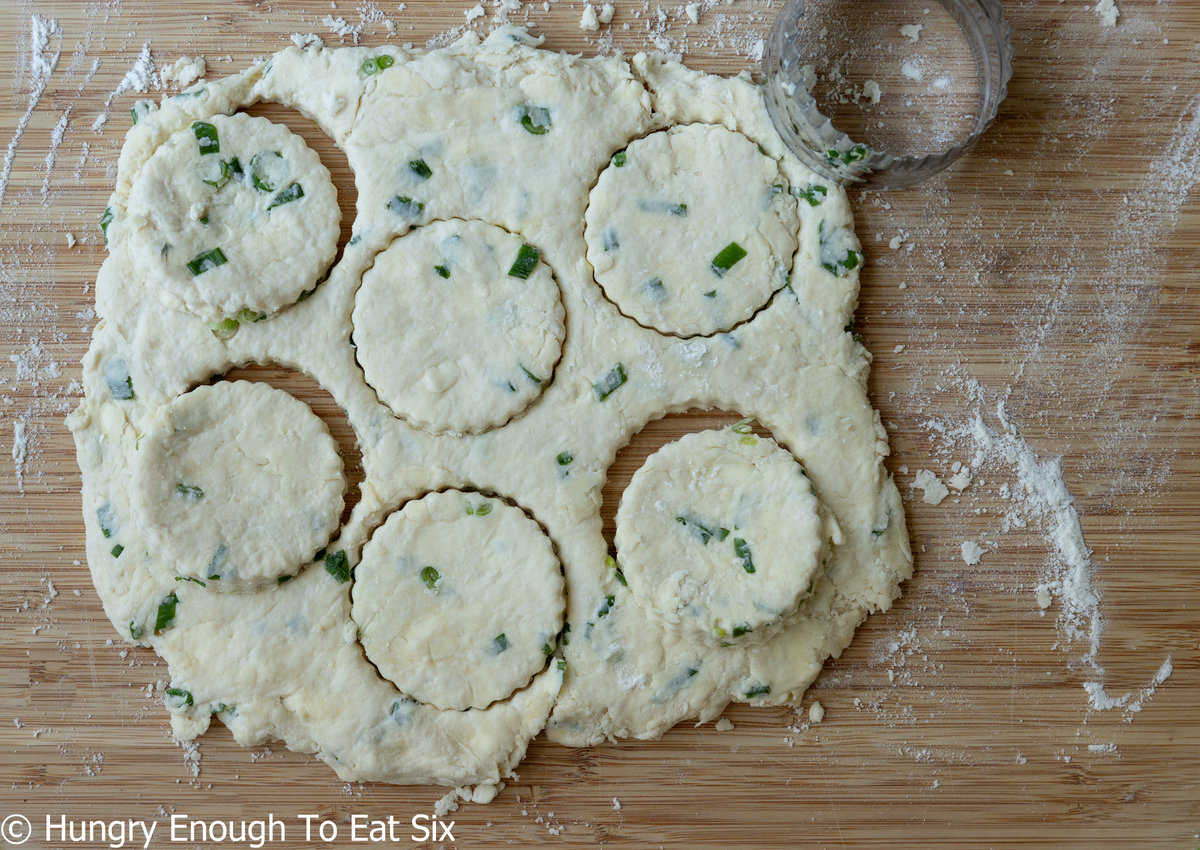 Biscuit dough with green onions rolled and cut.
