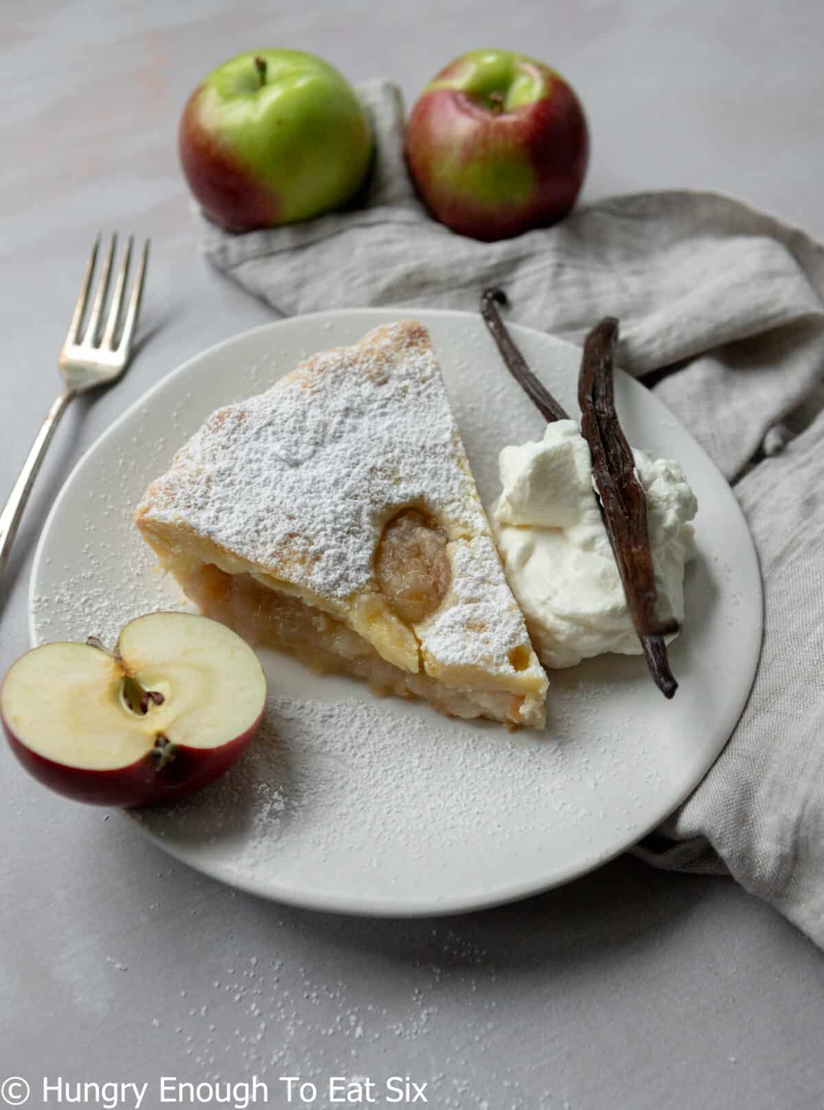 Slice of sugar topped apple pie with a fork.