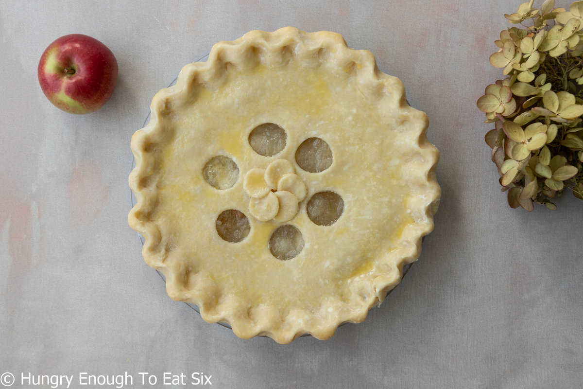 Unbaked pie with top crust and circle cutouts.