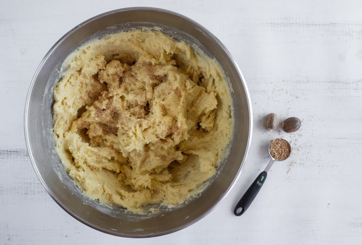 Cookie dough with grated nutmeg in a mixing bowl.