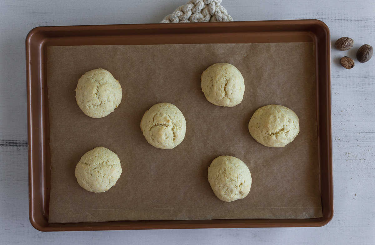 Baked round cookies on a lined baking sheet.