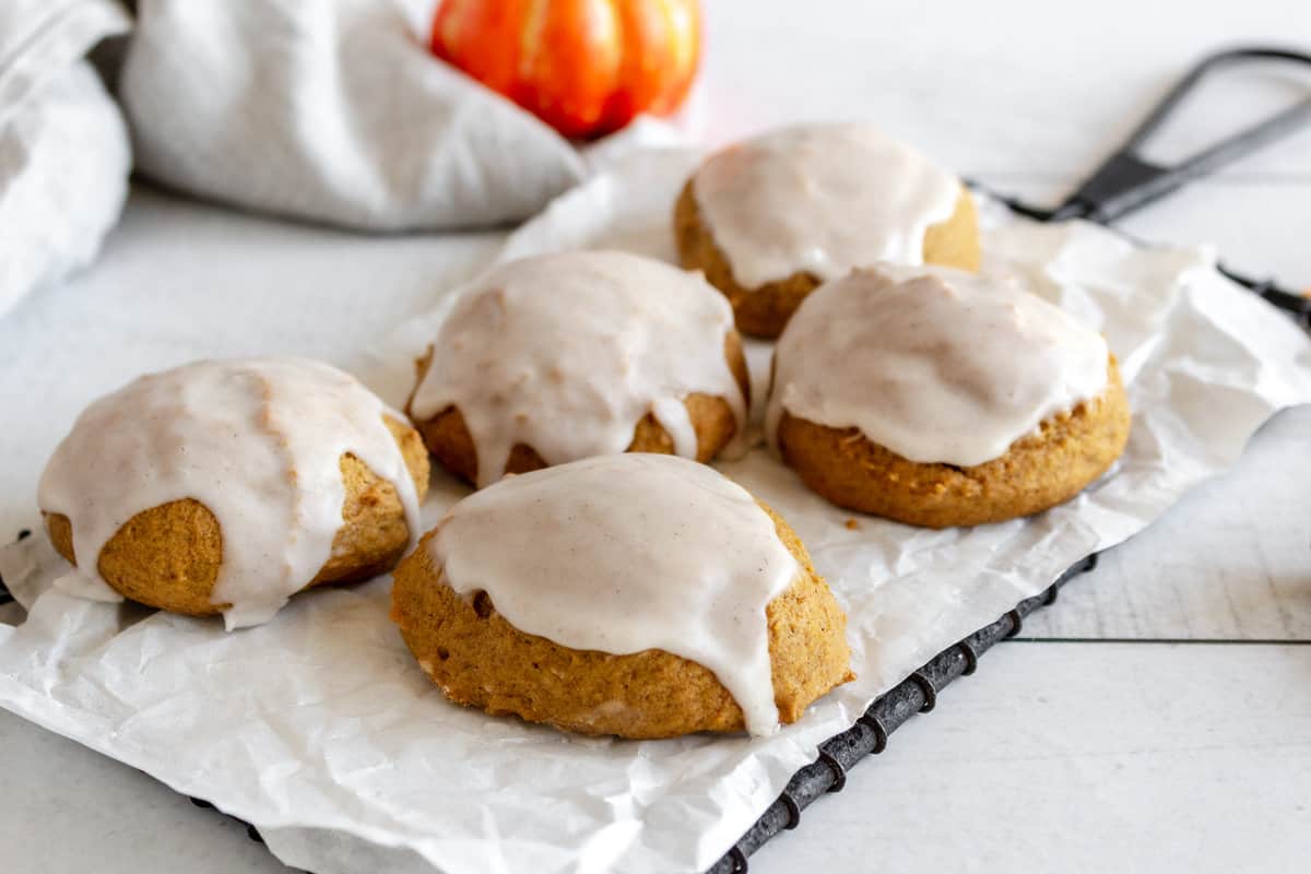 Five iced cookies made with pumpkin puree. 