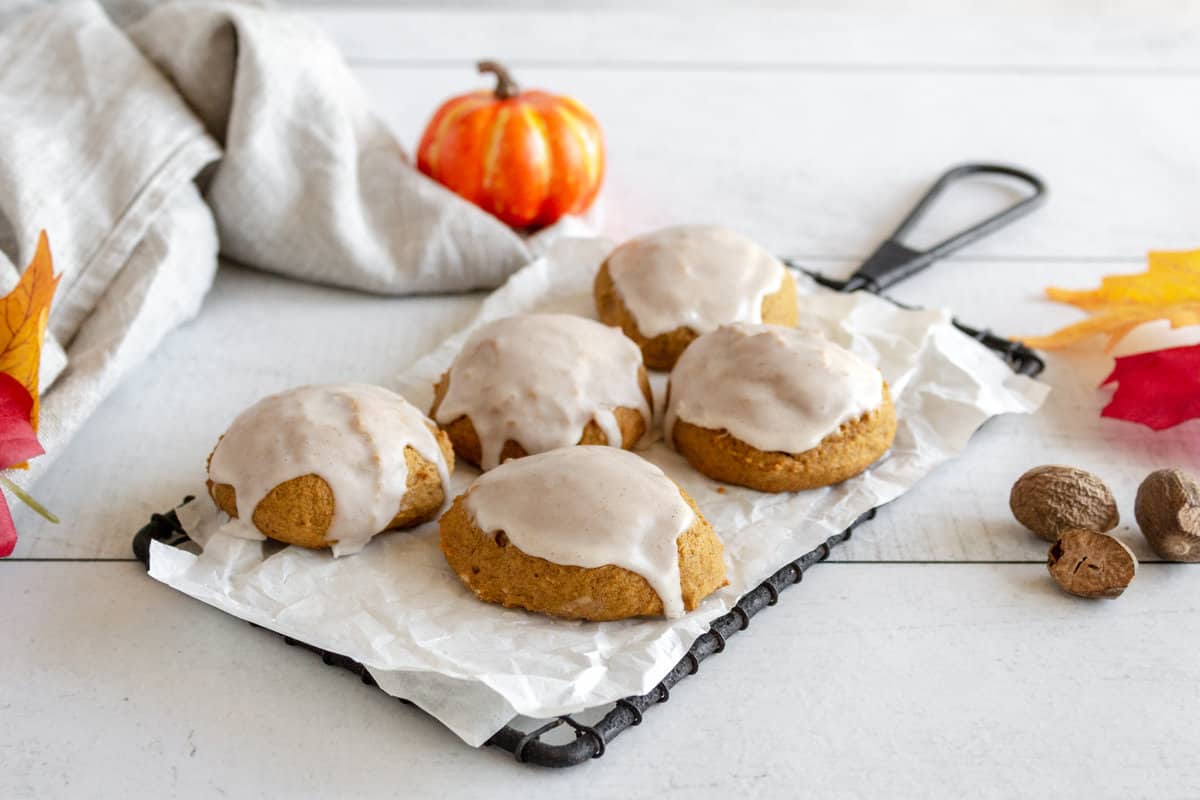 Five pumpkin flavored cookies with white icing.