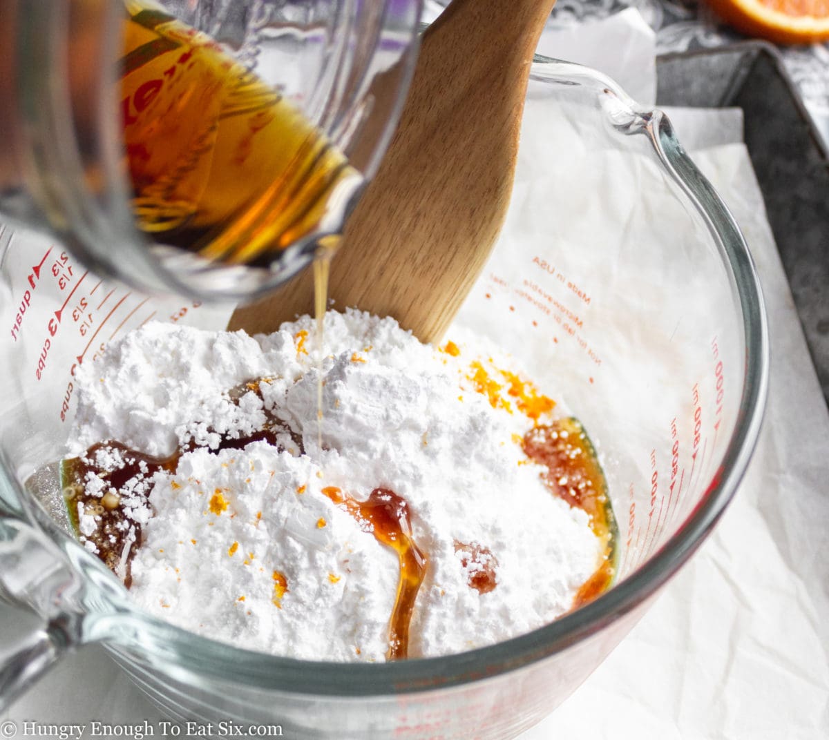 Glass measuring cup with powedered sugar and maple syrup