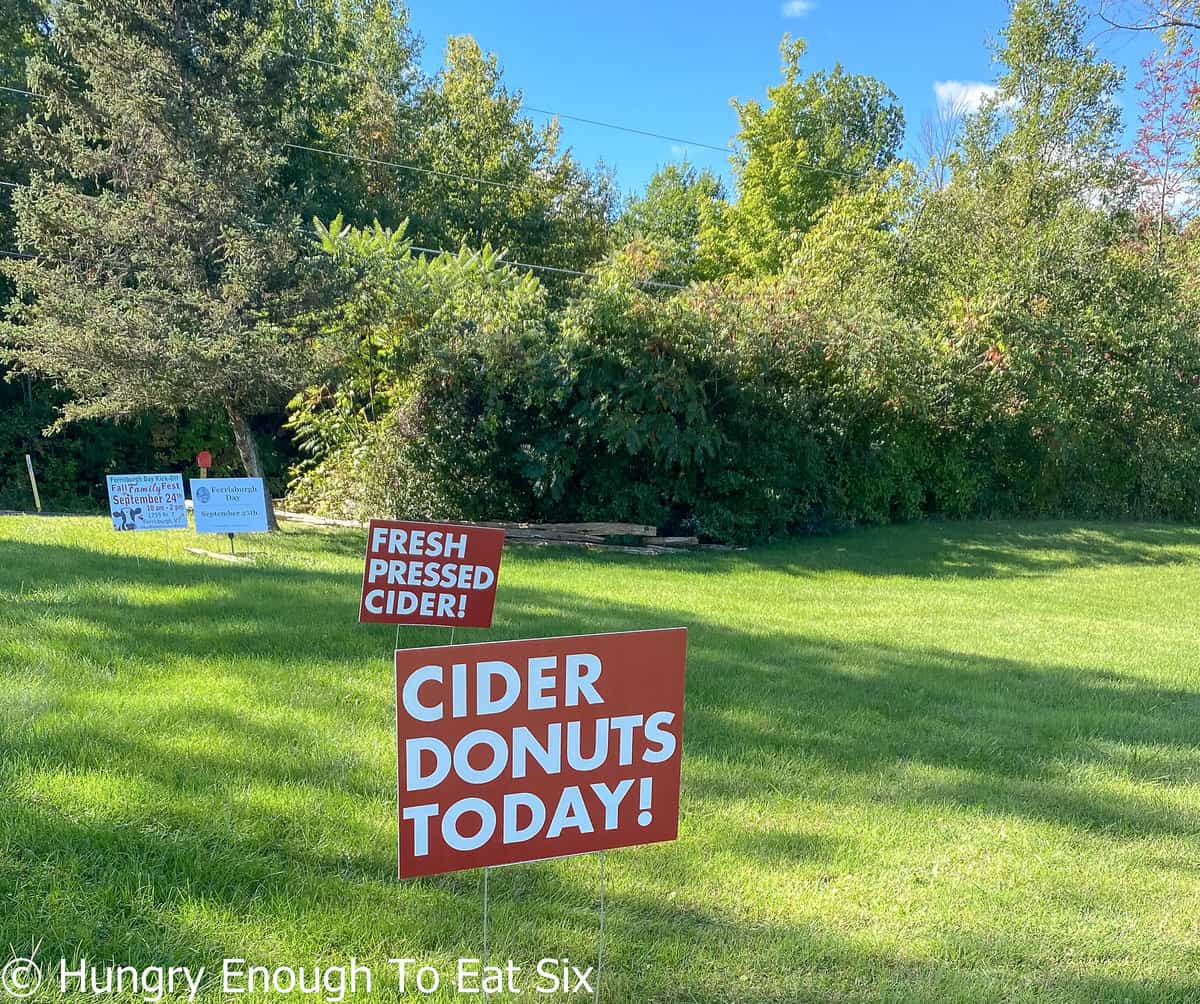 Red lawn signs that say Cider Donuts Today