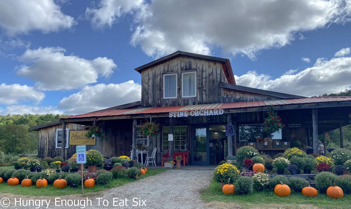 Gray board barn style store with plants and pumpkins. 