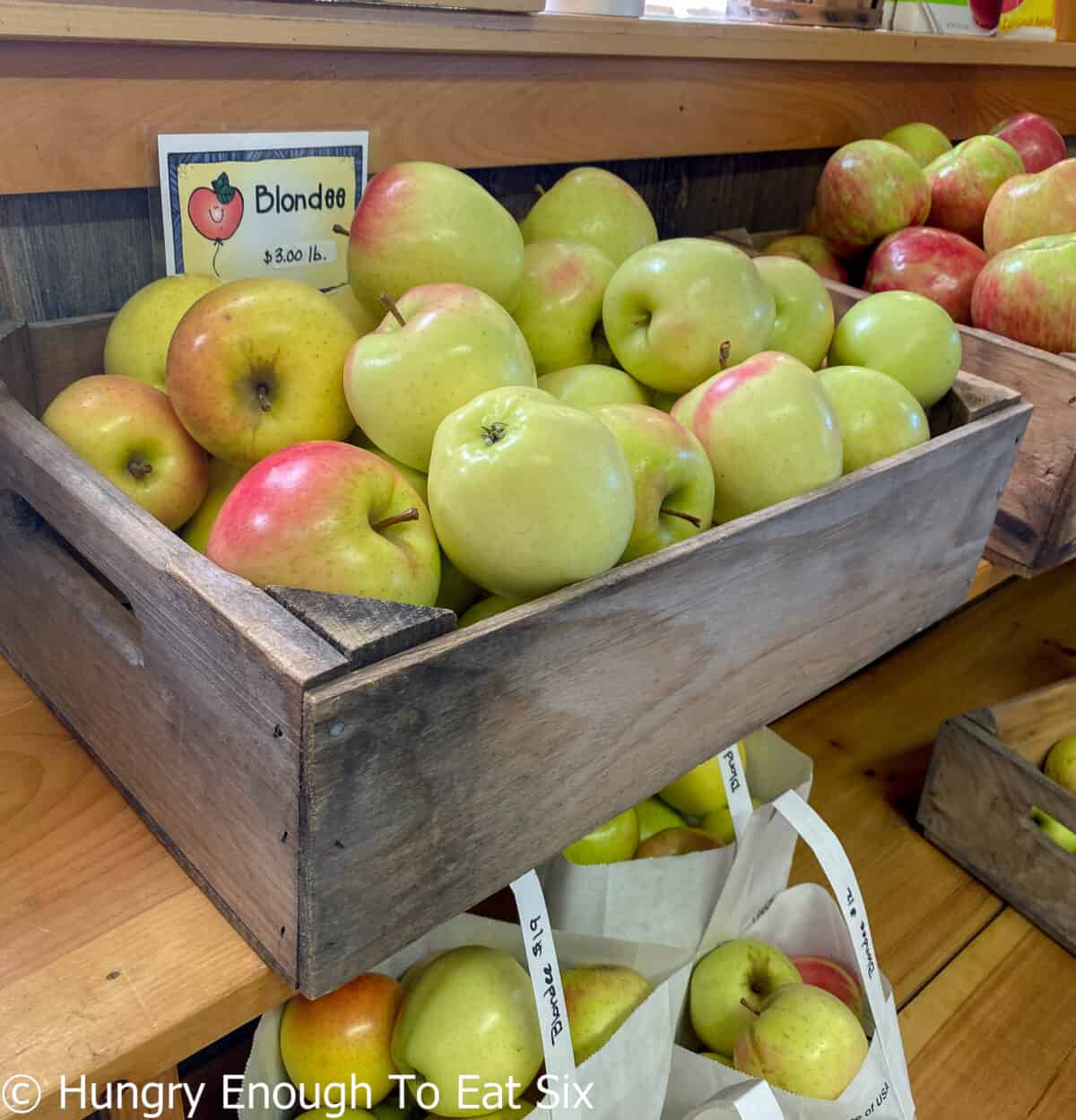 Wooden box of green and red apples.