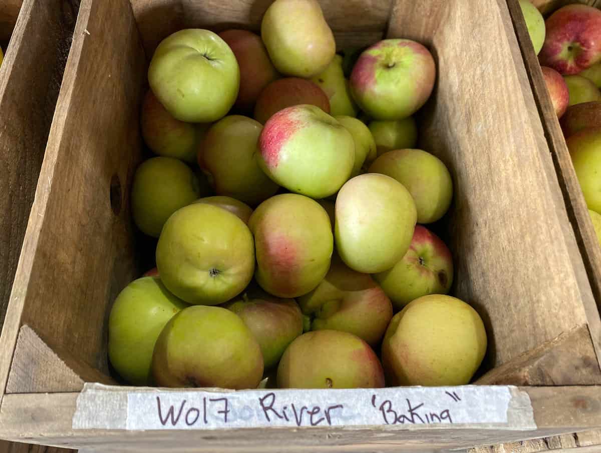 Wood crate of apples labeled with piece of tape.