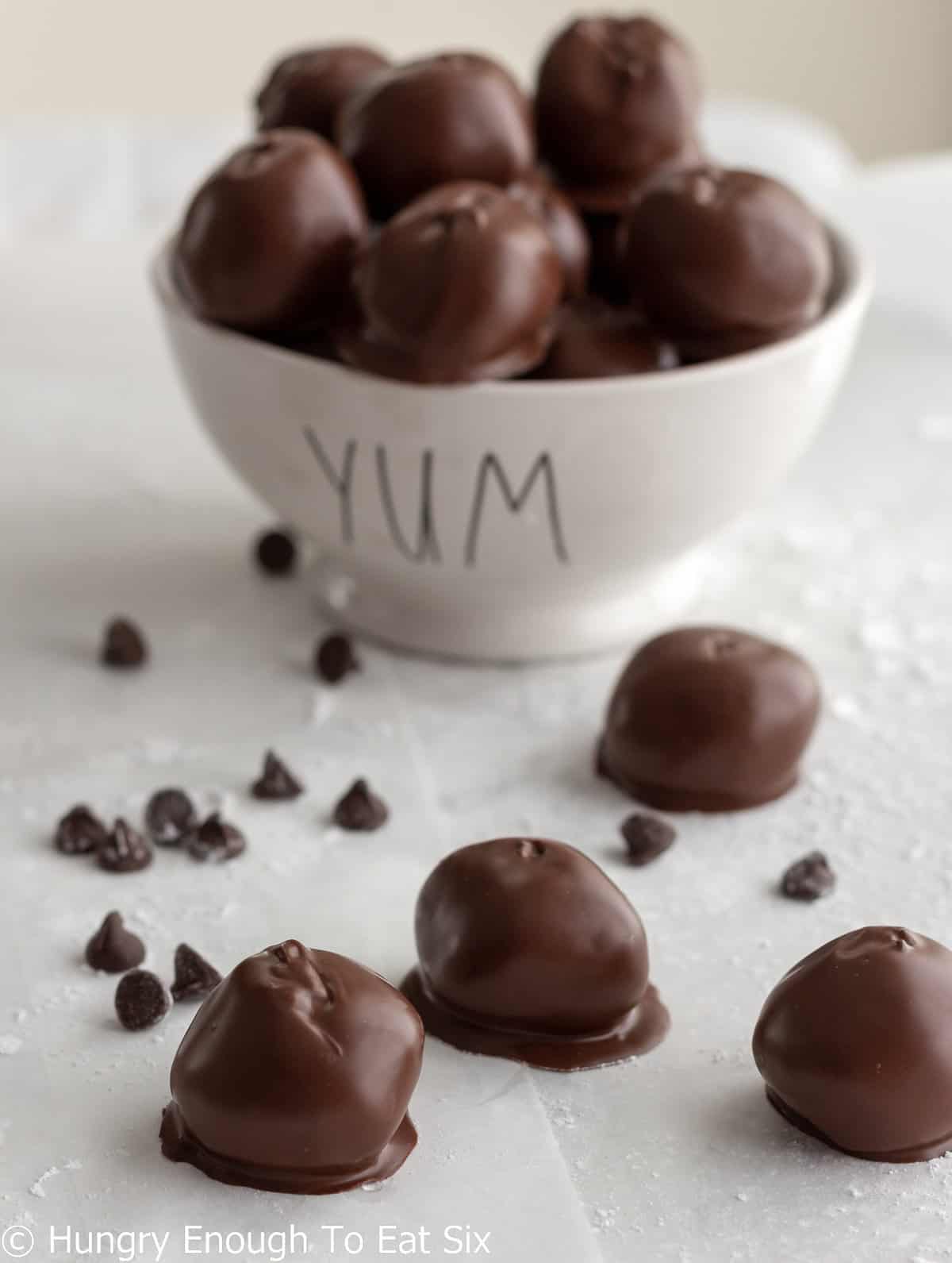 Chocolate covered peanut butter bonbons on table and in a bowl.