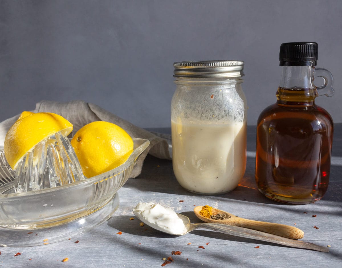 Jar of dressing with maple syrup and lemon slices