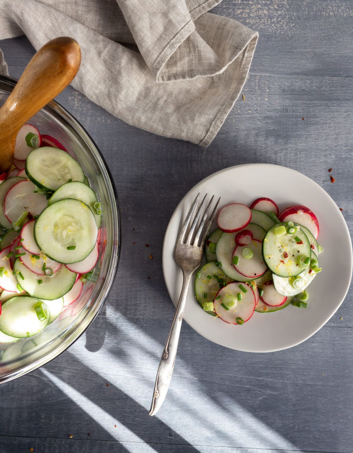 Bowl of cucumber salad with some on a plate
