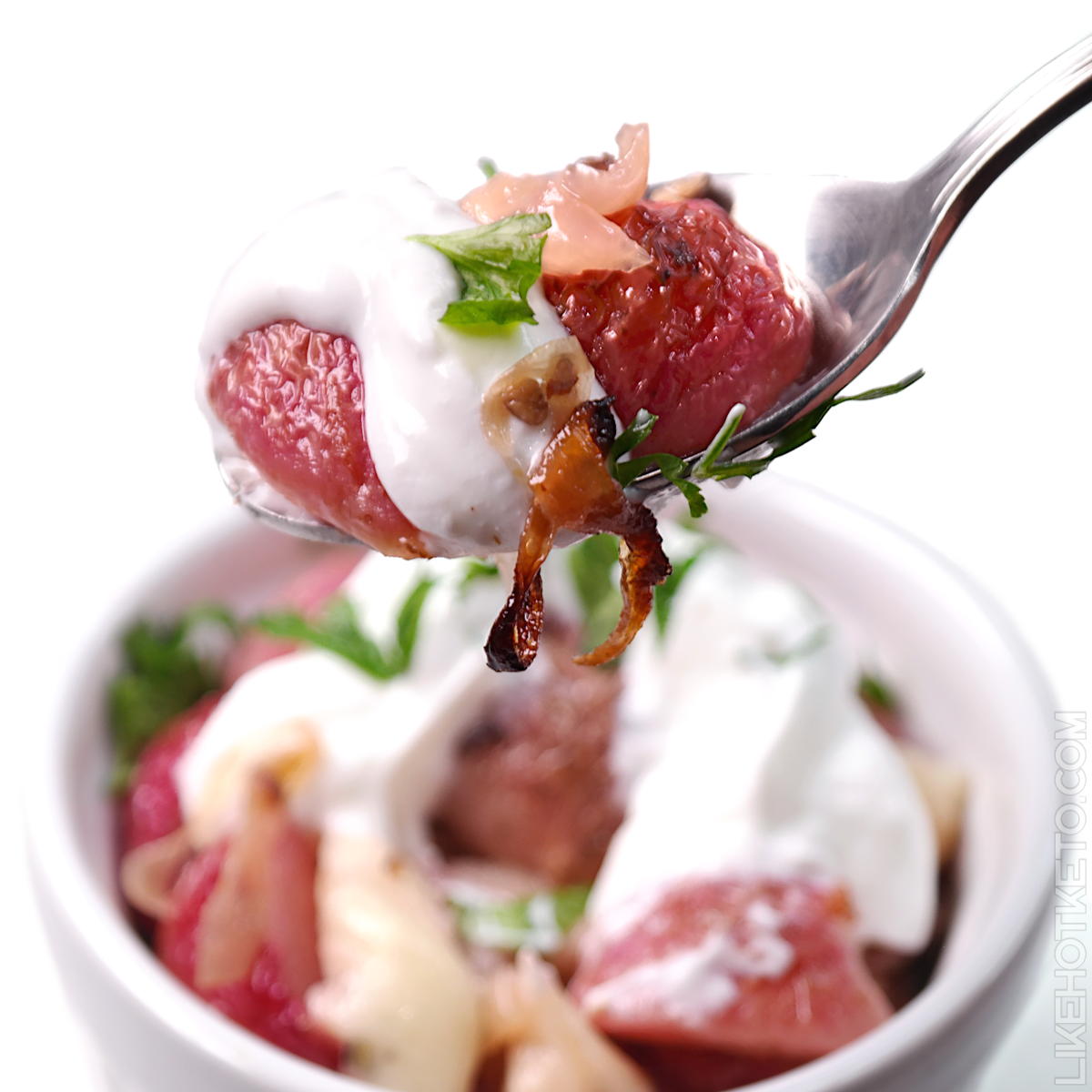 Forkful of radish salad topped with cream and herbs,