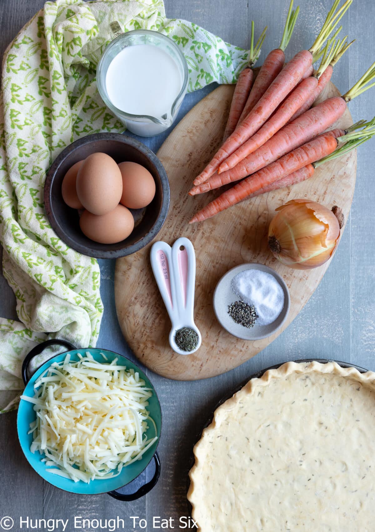 Carrots, eggs, spices, shredded cheese, cream, and a pie crust.