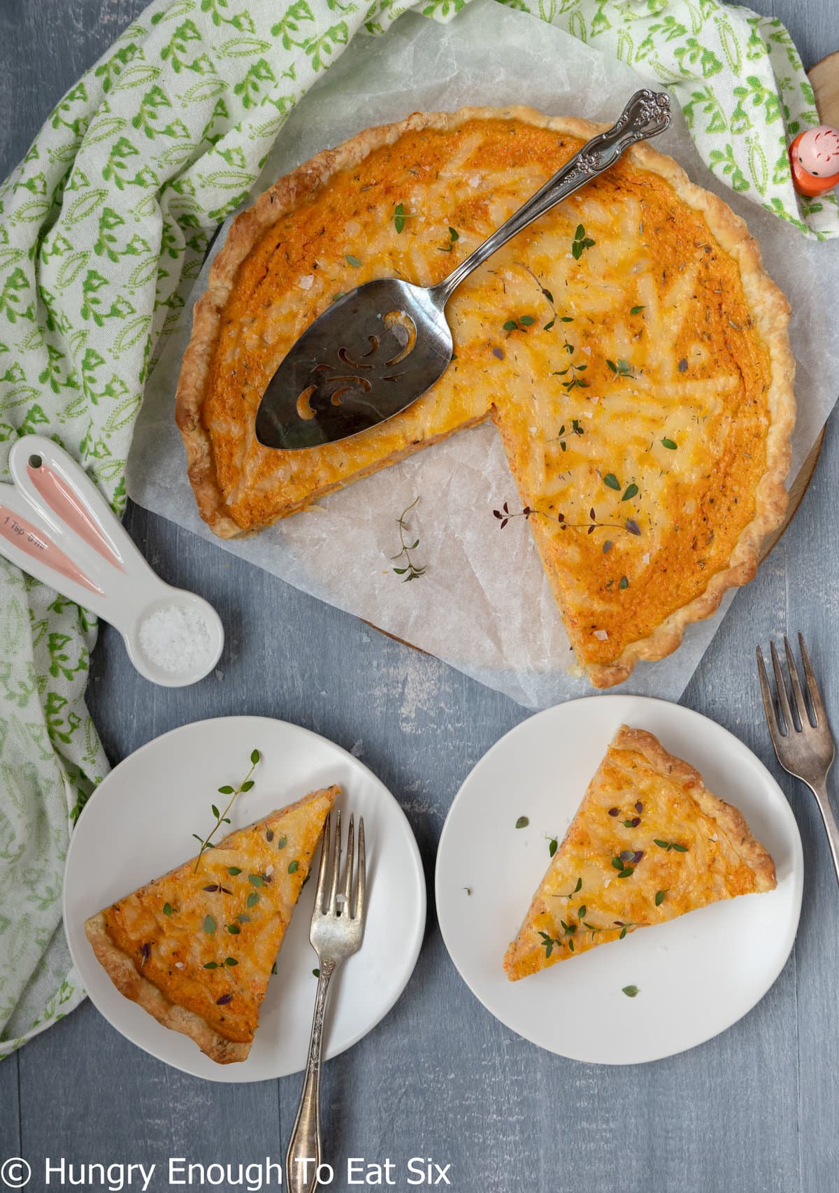 Whole carrot quiche with slices out on plates.