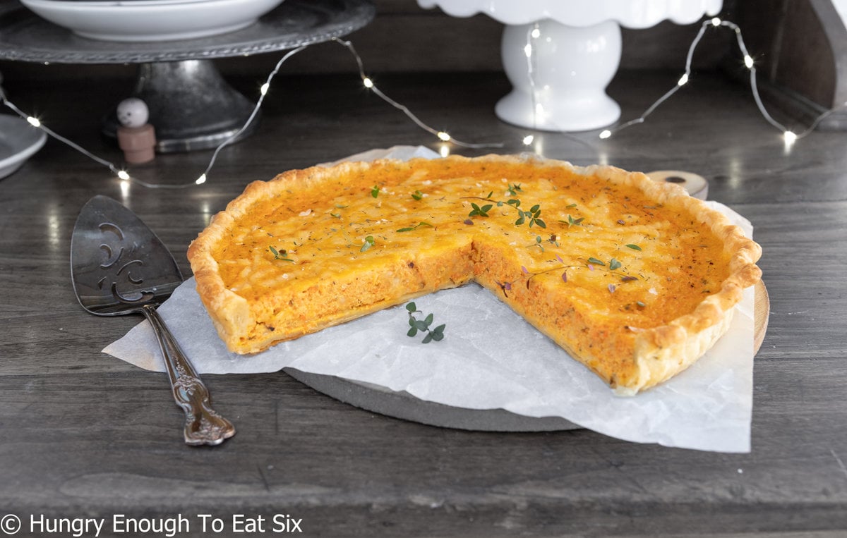 Carrot quiche with wedge taken out.
