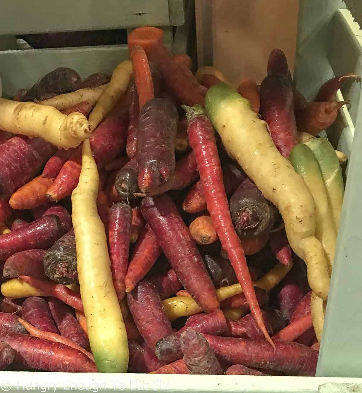 Box of purple, red, and white carrots.