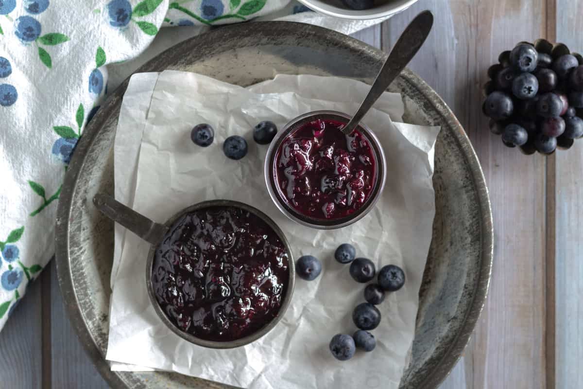 Jar and scoop of dark blueberry ketchup.