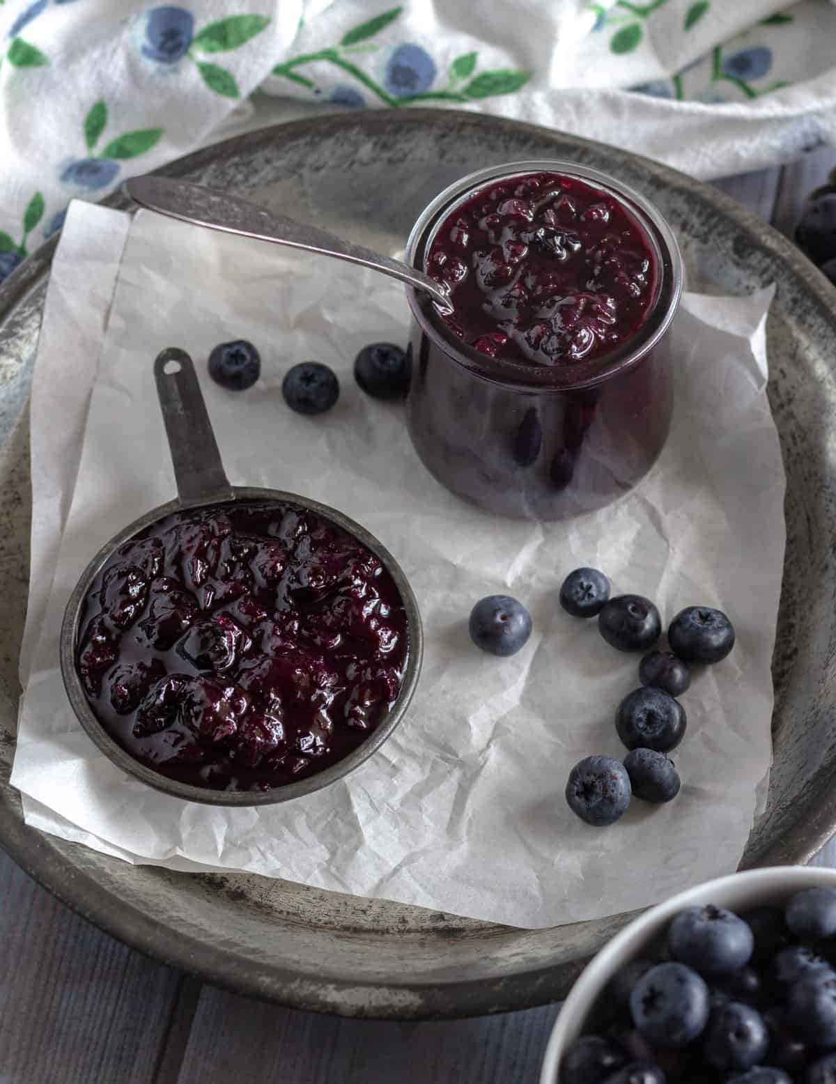 Blueberries with jars of blueberry ketchup.