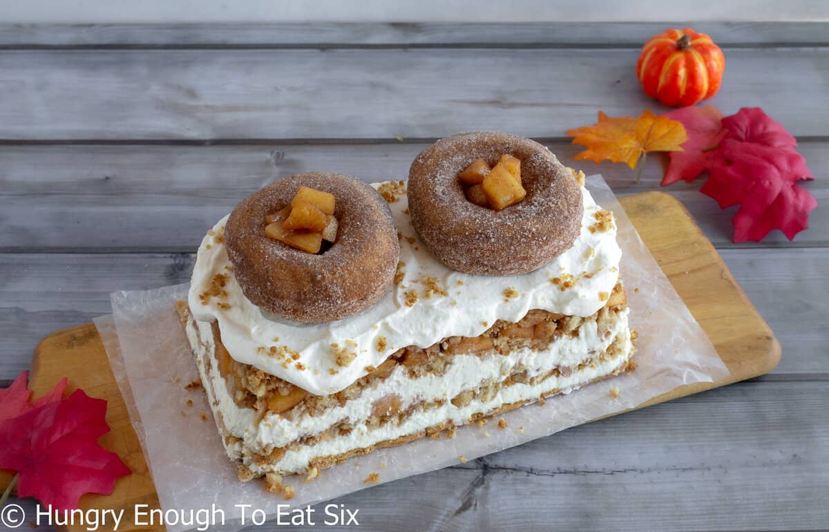 Icebox cake with donut crumb layers and donuts on top. 