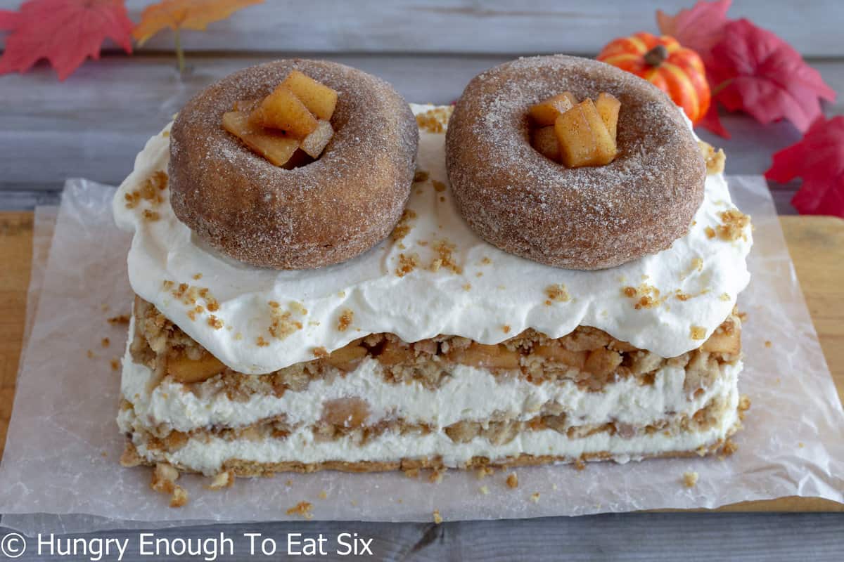 Long narrow icebox cake with cream, apple bits, and cider donuts.