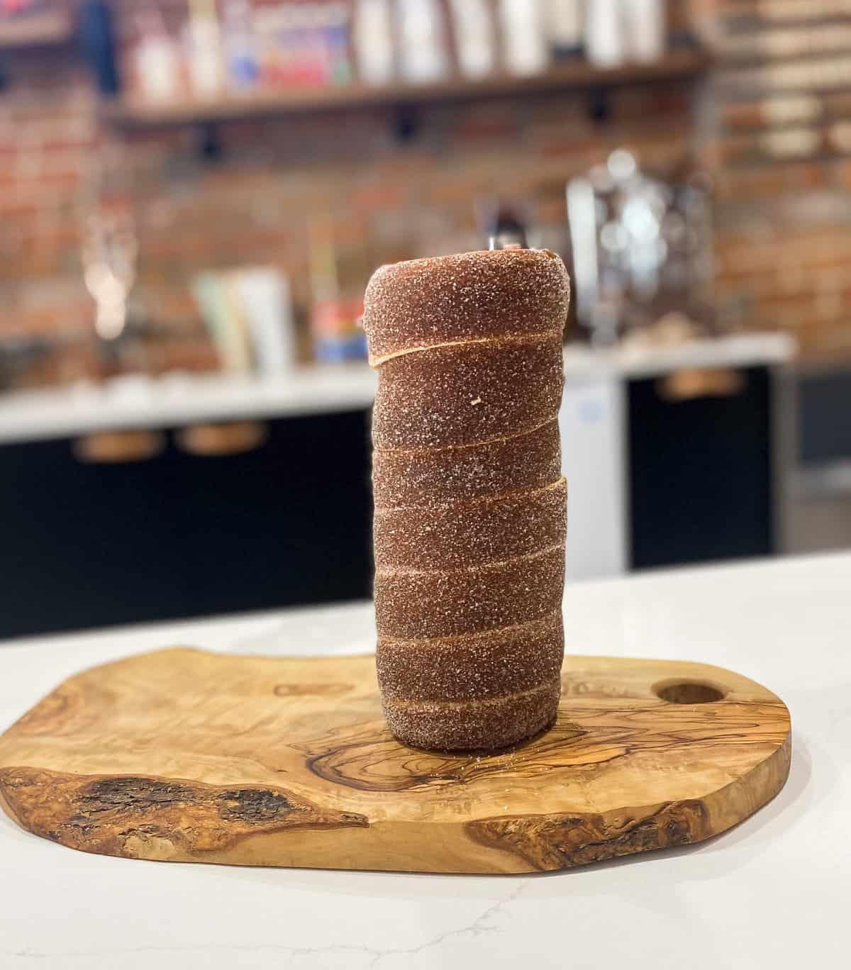 Spiral shaped cone of baked pastry on wood board.