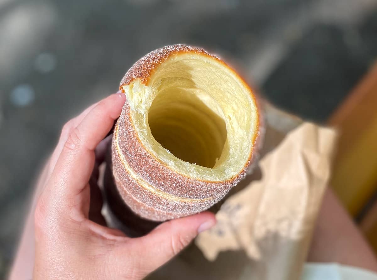 Hollow cylinder of baked pastry in a hand.
