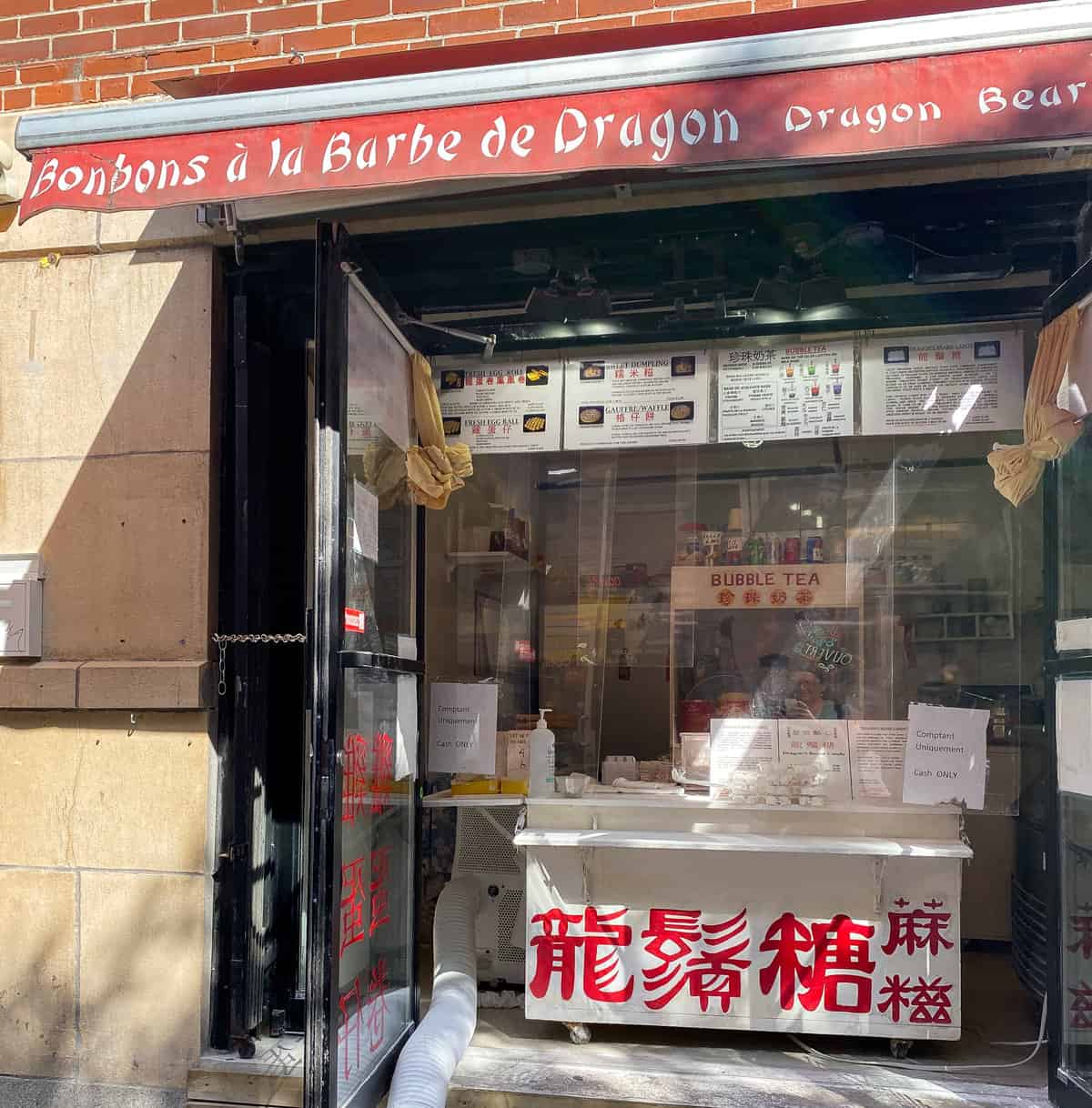 Shop entrance with red awning and Chinese characters on counter.