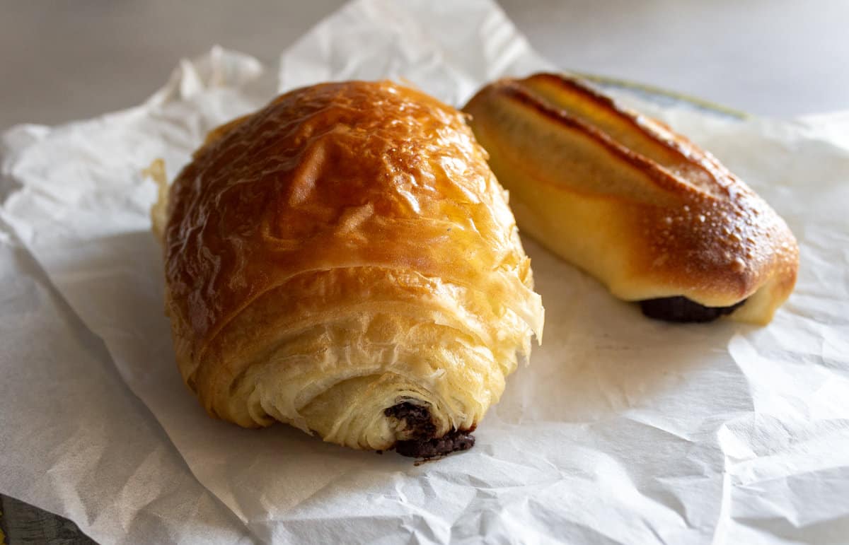 Baked croissant and bun both with chocolate filling.