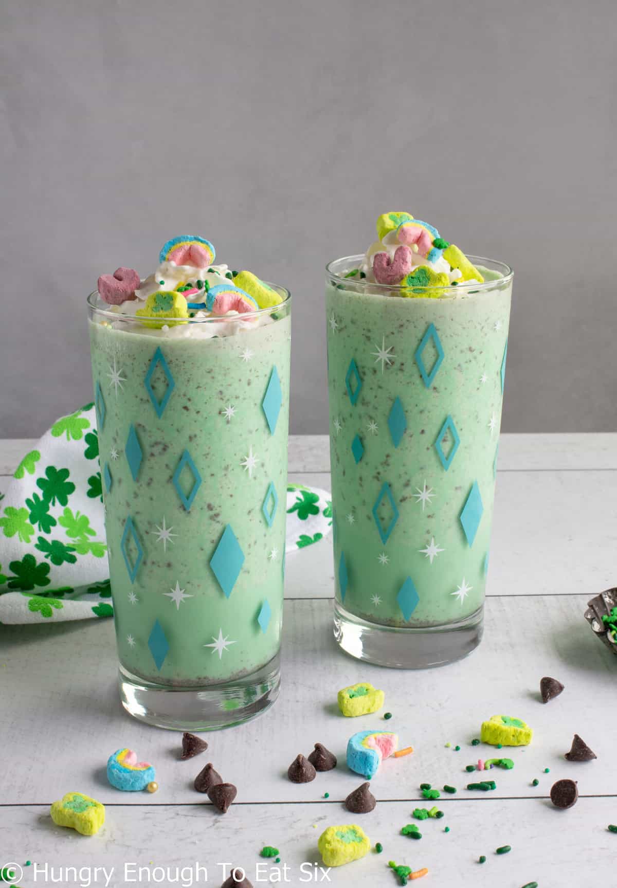Two green milkshakes with Lucky Charms marshmallows.