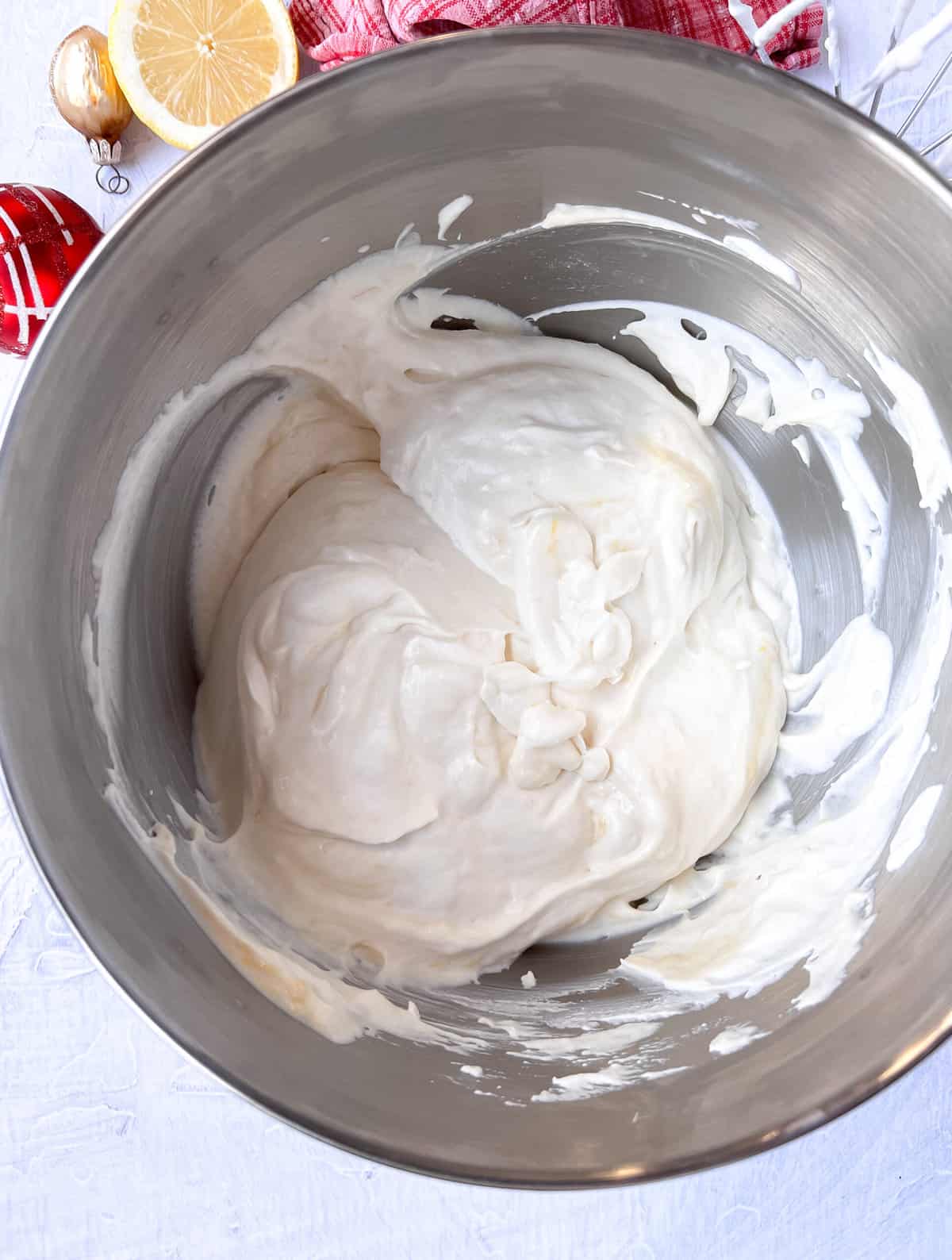 Whipped cream in a silver mixing bowl.